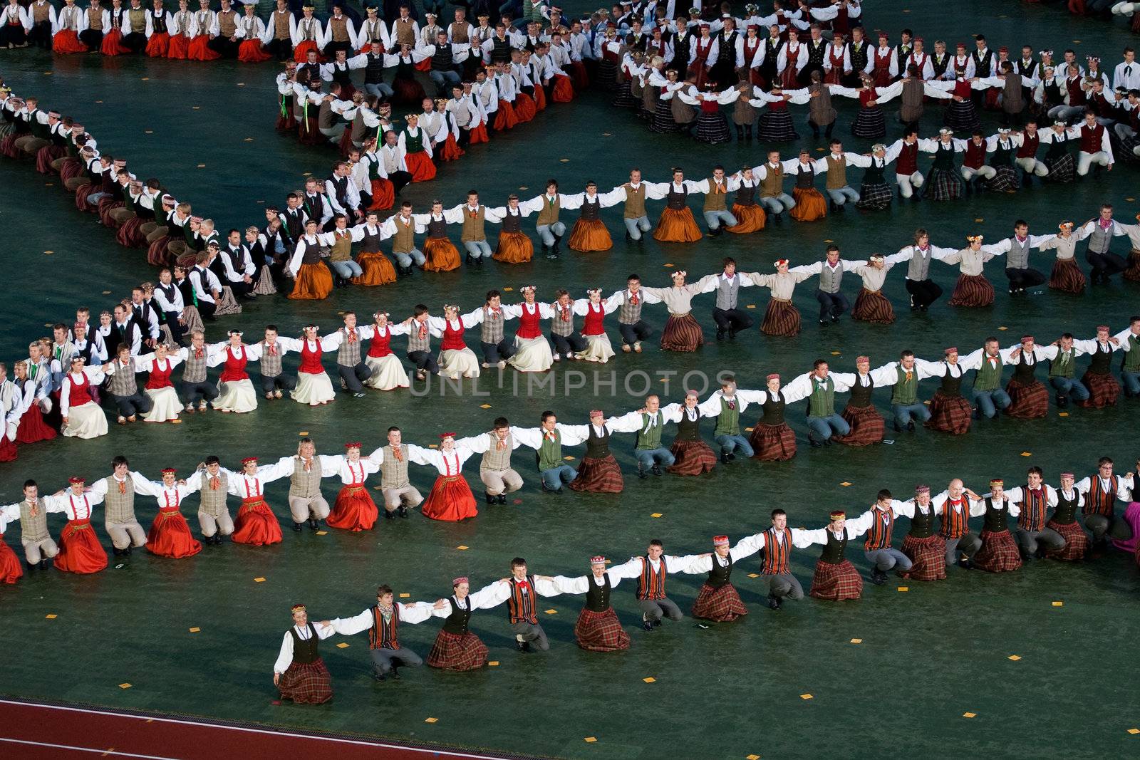 RIGA - JULY 9: Dancers in traditional costumes perform at the dress rehearsal of Grand Dance Performance during the Latvian Nationwide Song and Dance Celebration in Riga, Latvia, 9 July, 2008