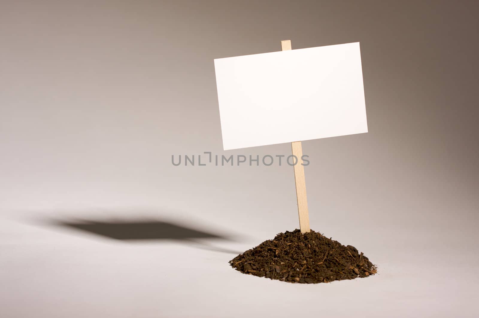 Blank white sign in mount of dirt ready for your own message.