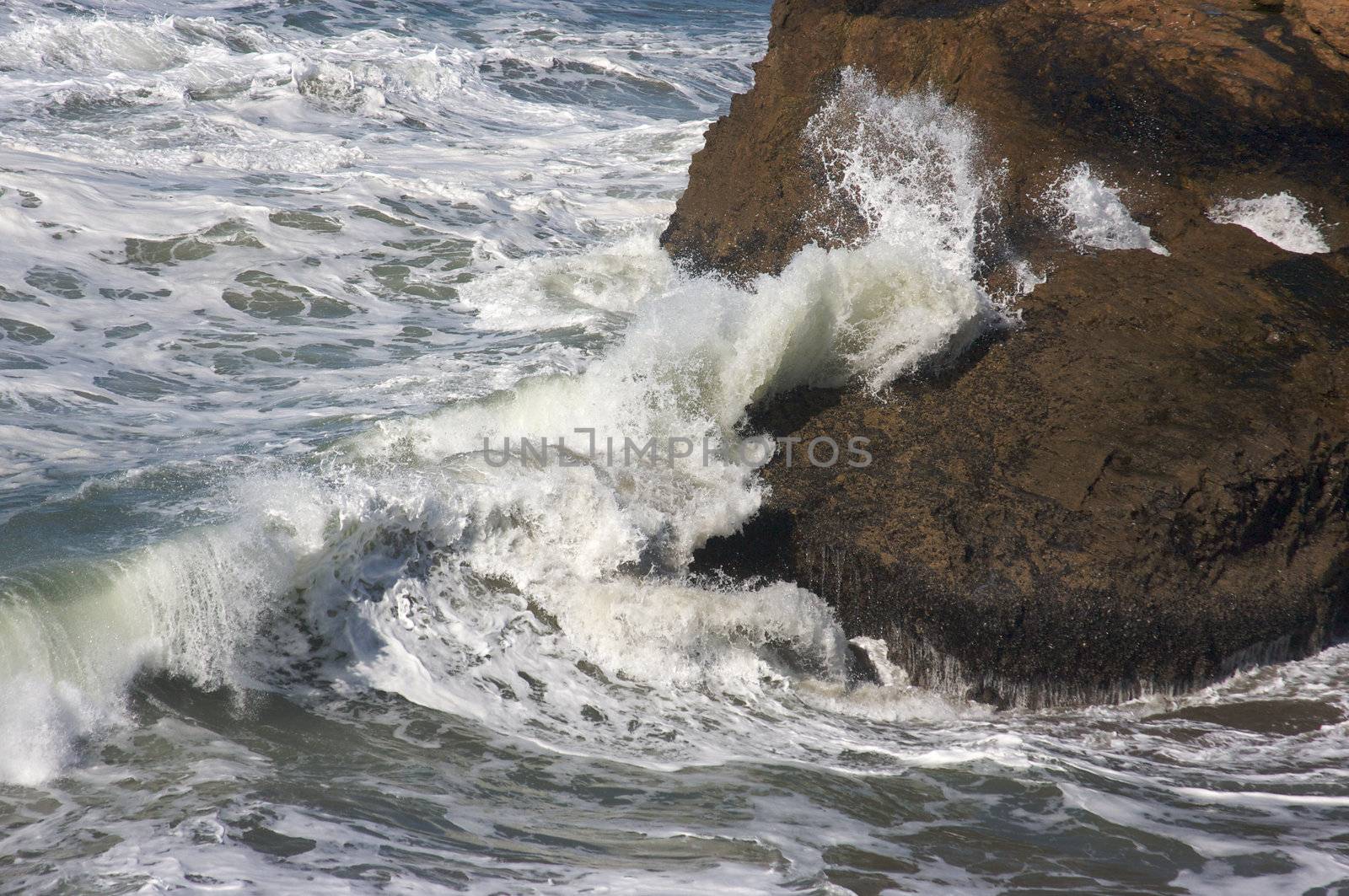 Pacific Ocean Waves break against the rocks.