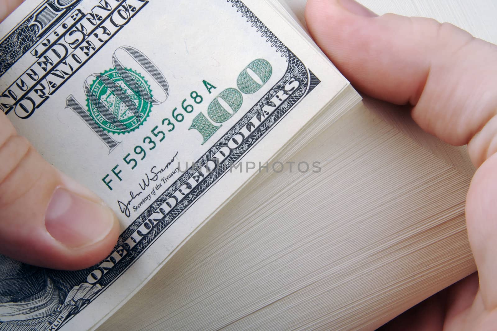 Man Fanning Large Stack of One Hundred Dollar Dollar Bills