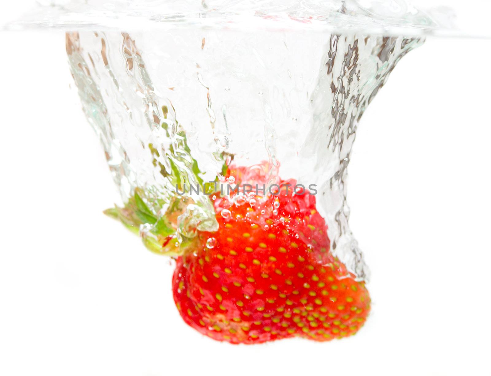 close-up splashing strawberry, isolated on white