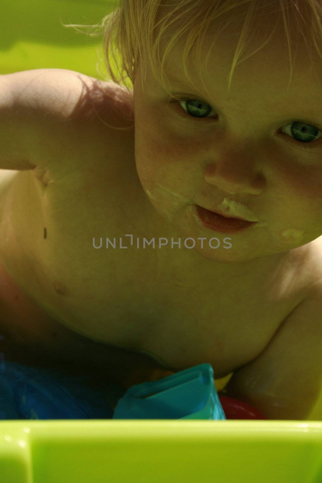 toddler taking a bath in a tub outside on a hot summer day.