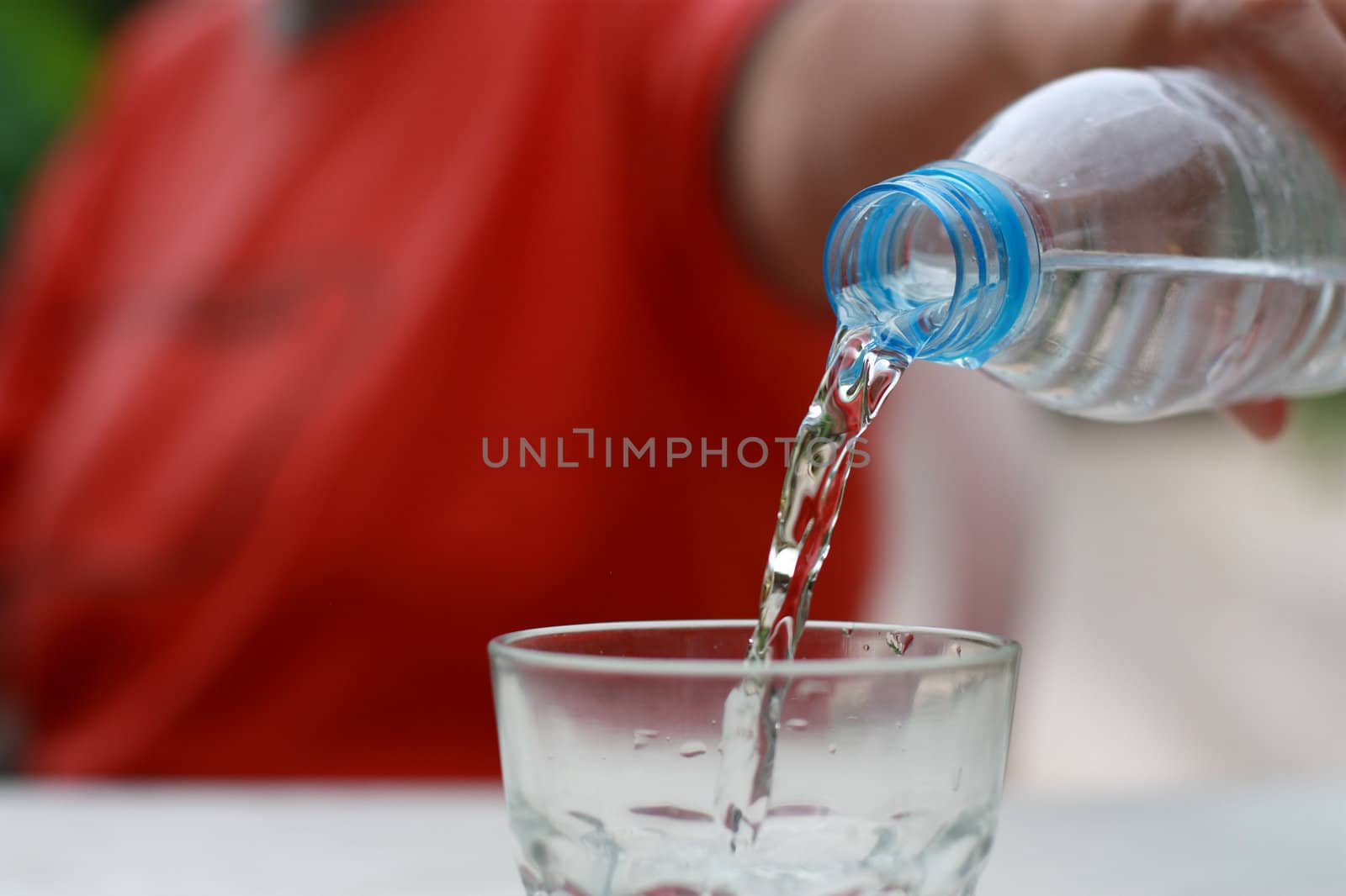 bottle of clean water being poured in a glass.narrow DOF