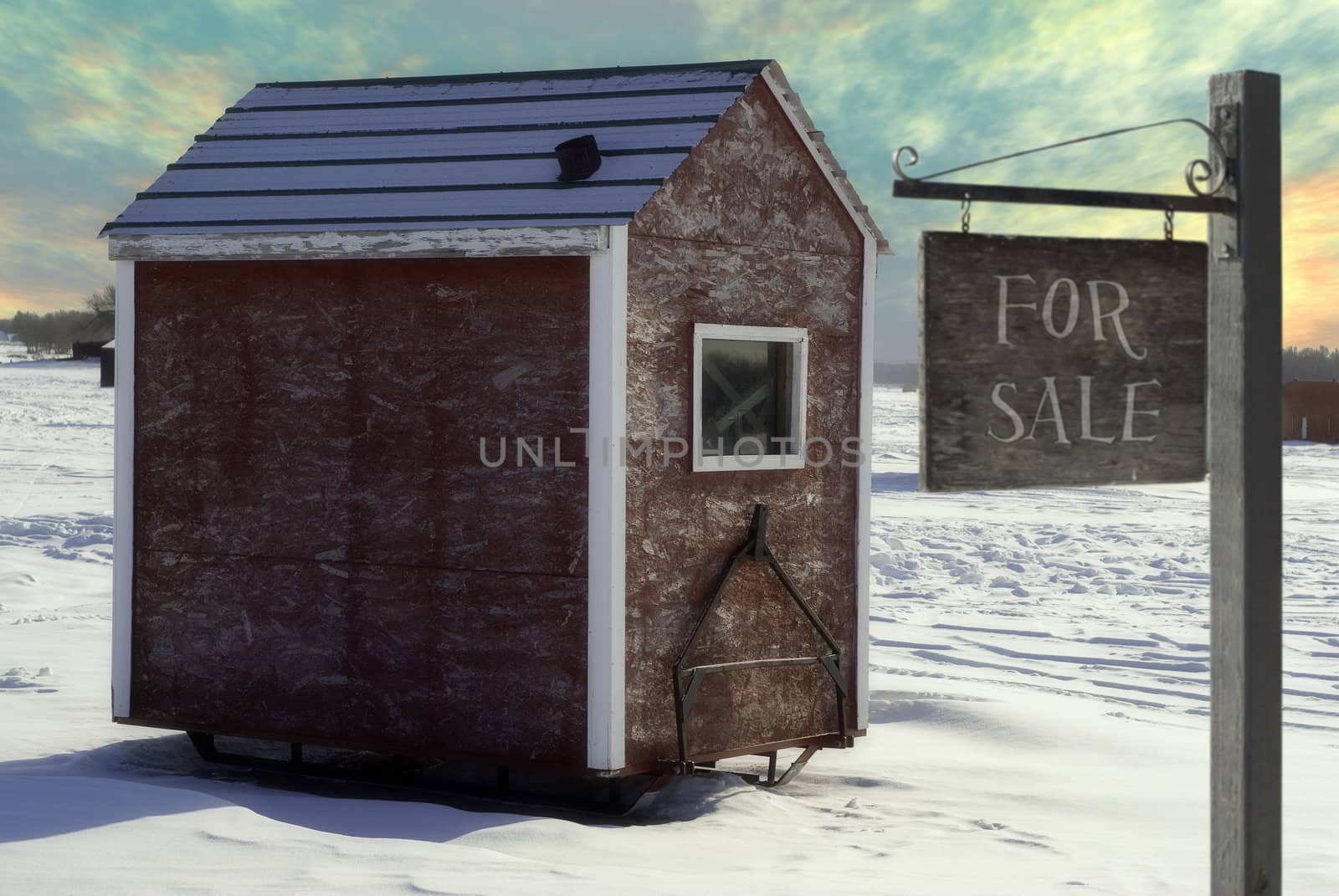 An ice fishing shed is for sale with a sign saying so.