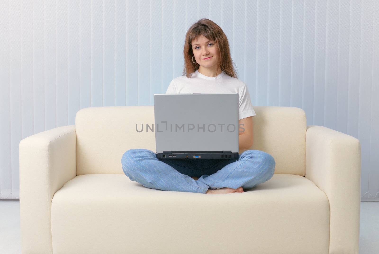 The girl sitting on the couch with a laptop