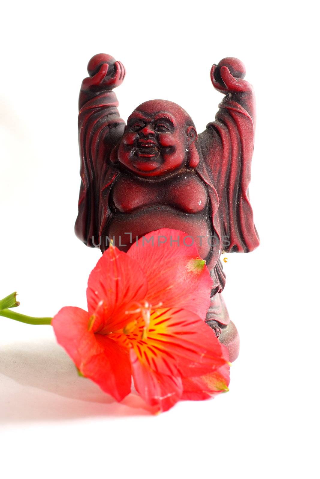 Red Buddha statue with red Peruvian lilies