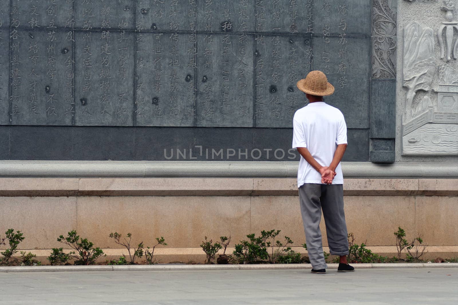 Chinese man reading a text carved on stone