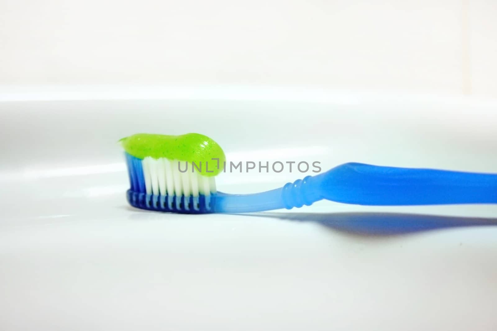 toothbrush with paste for cleaning teeth on background of the washstand