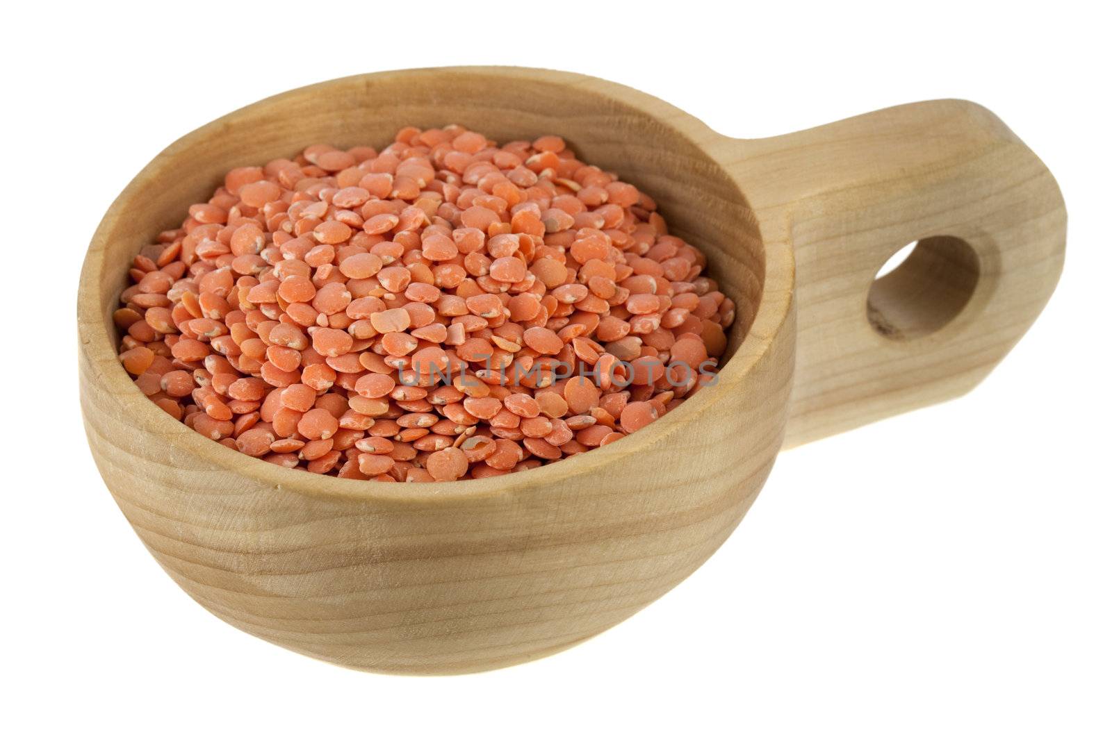 red lentils on a rustic wooden scoop (bowl), isolated on white