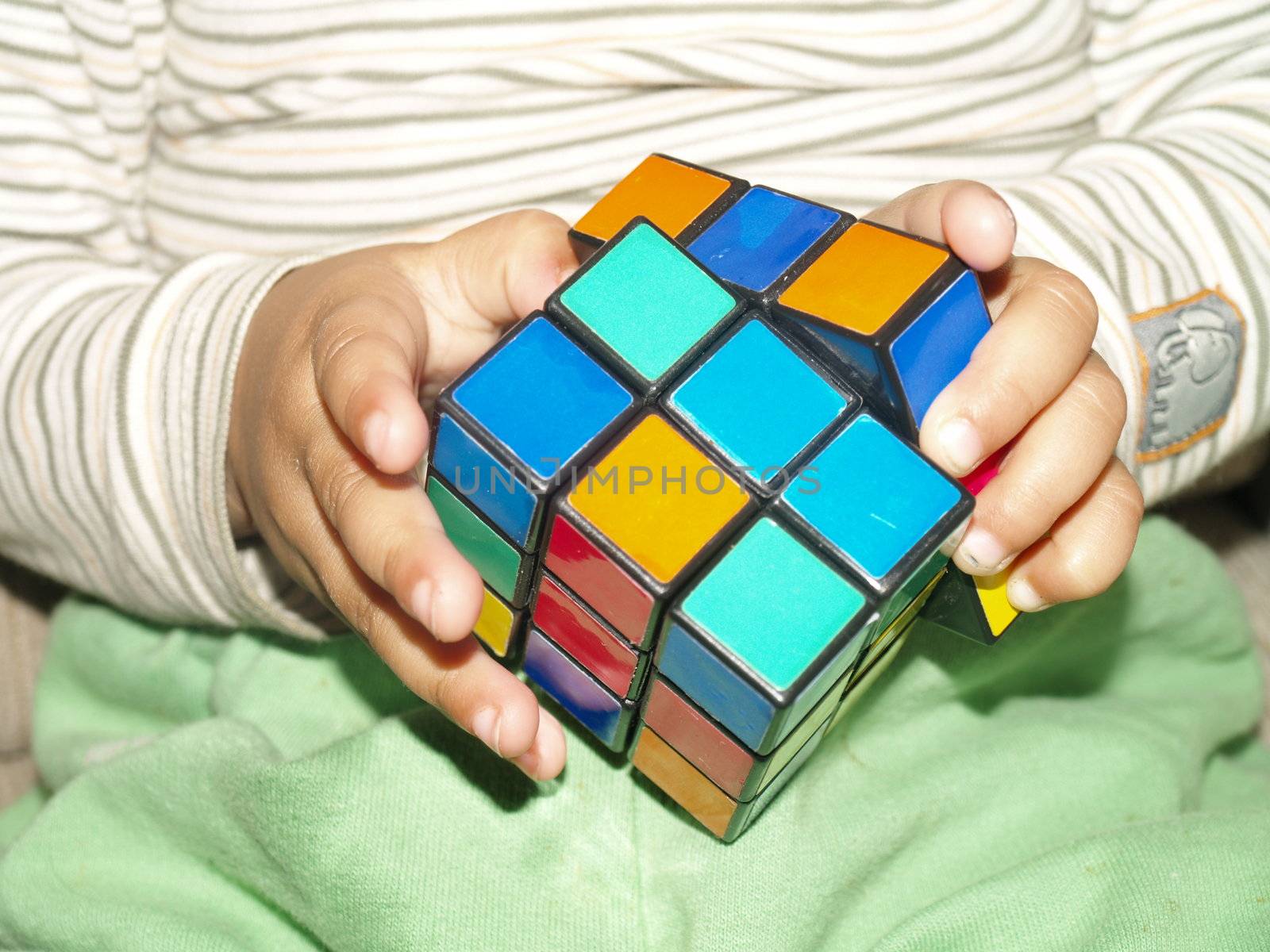 childs hand playing with magic cube