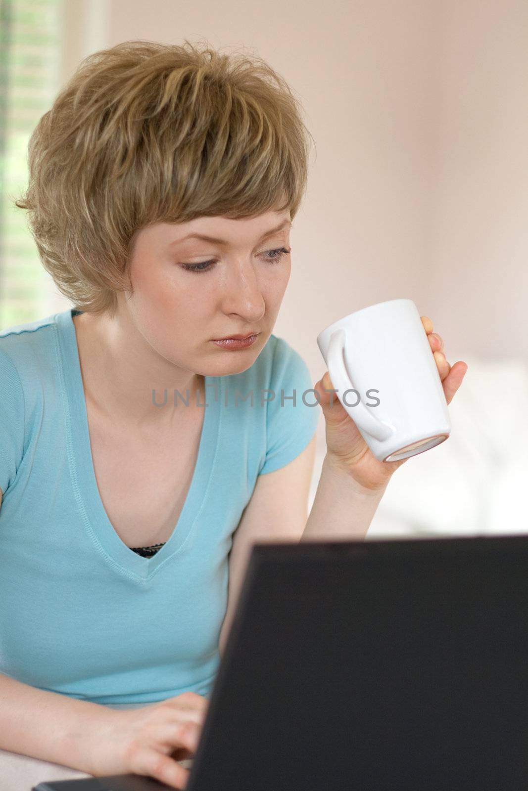young woman working on a laptop, indoors, shallow DOF