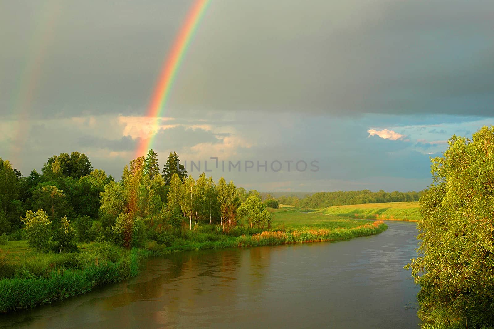 Rainbow above the river Dubna (Russia) in the summer evening.