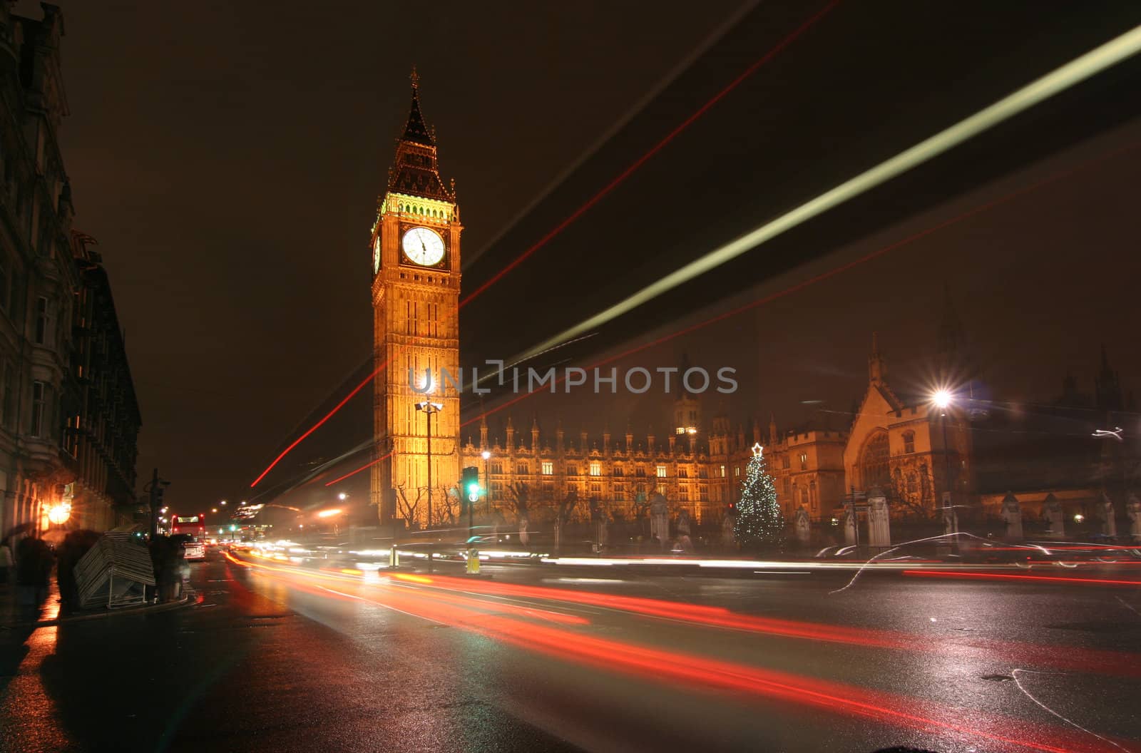 London. Big Ben at night with trails of light of passing traffic