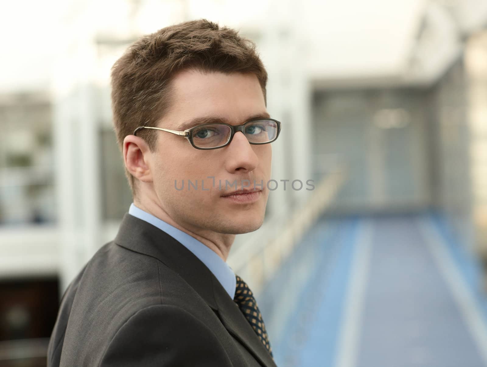 Portrait of young businessman in modern business office building corridor