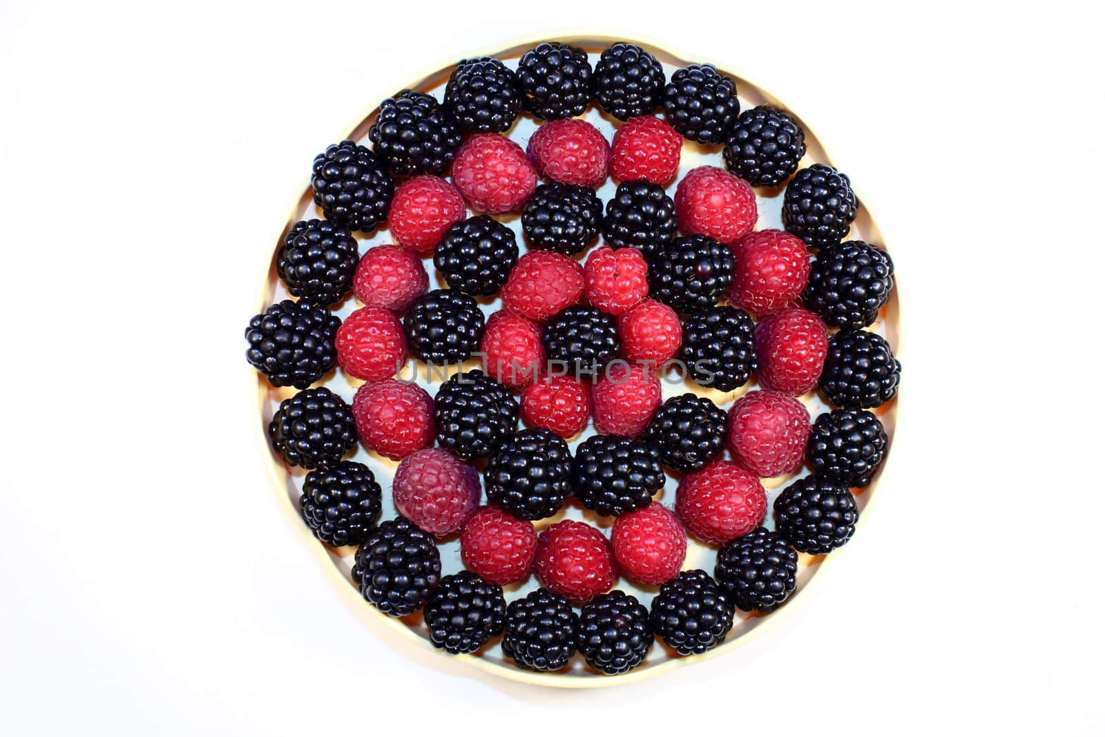 Fresh raspberries and blackberries in a little dish, ordered in a circle