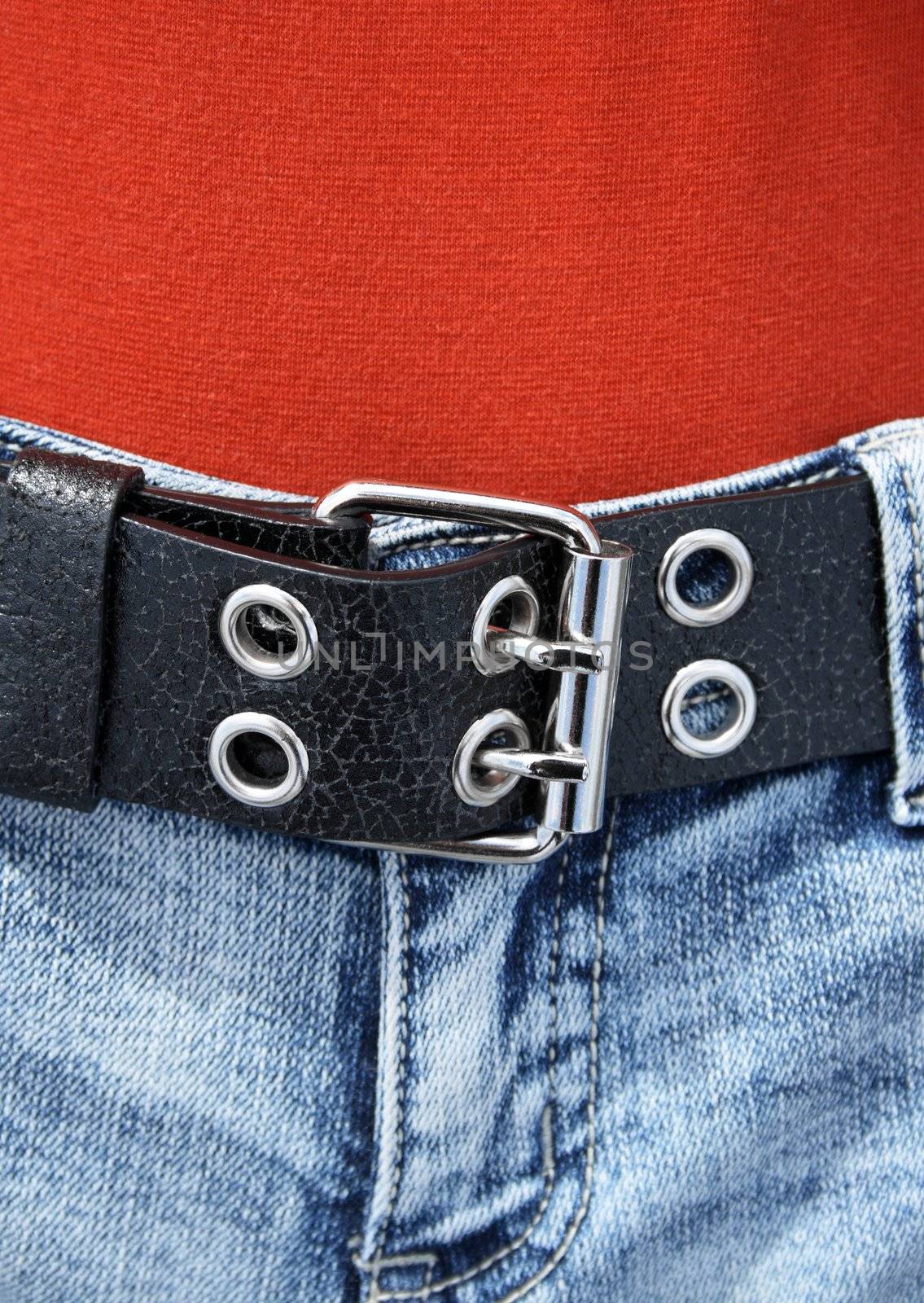 Black leather belt with metal buckle, worn with orange shirt and blue jeans.
