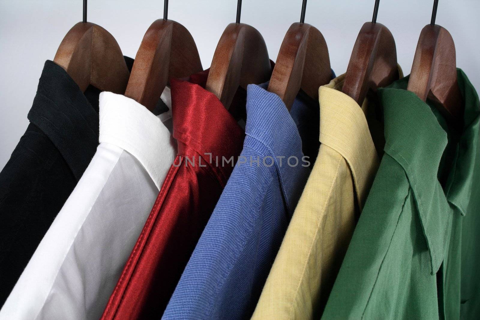 Man's wear - choice of colorful shirts on wooden hangers.