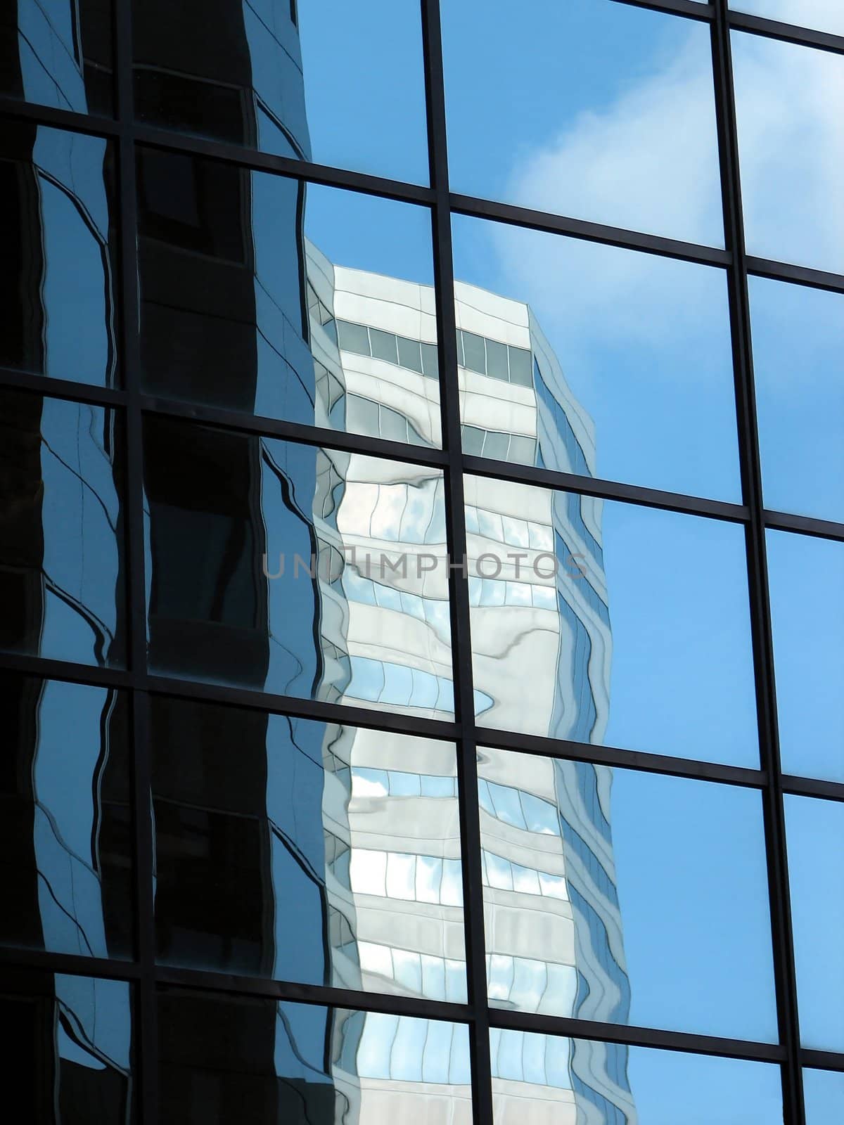 Corporate tower reflecting another office building and the sky by anikasalsera