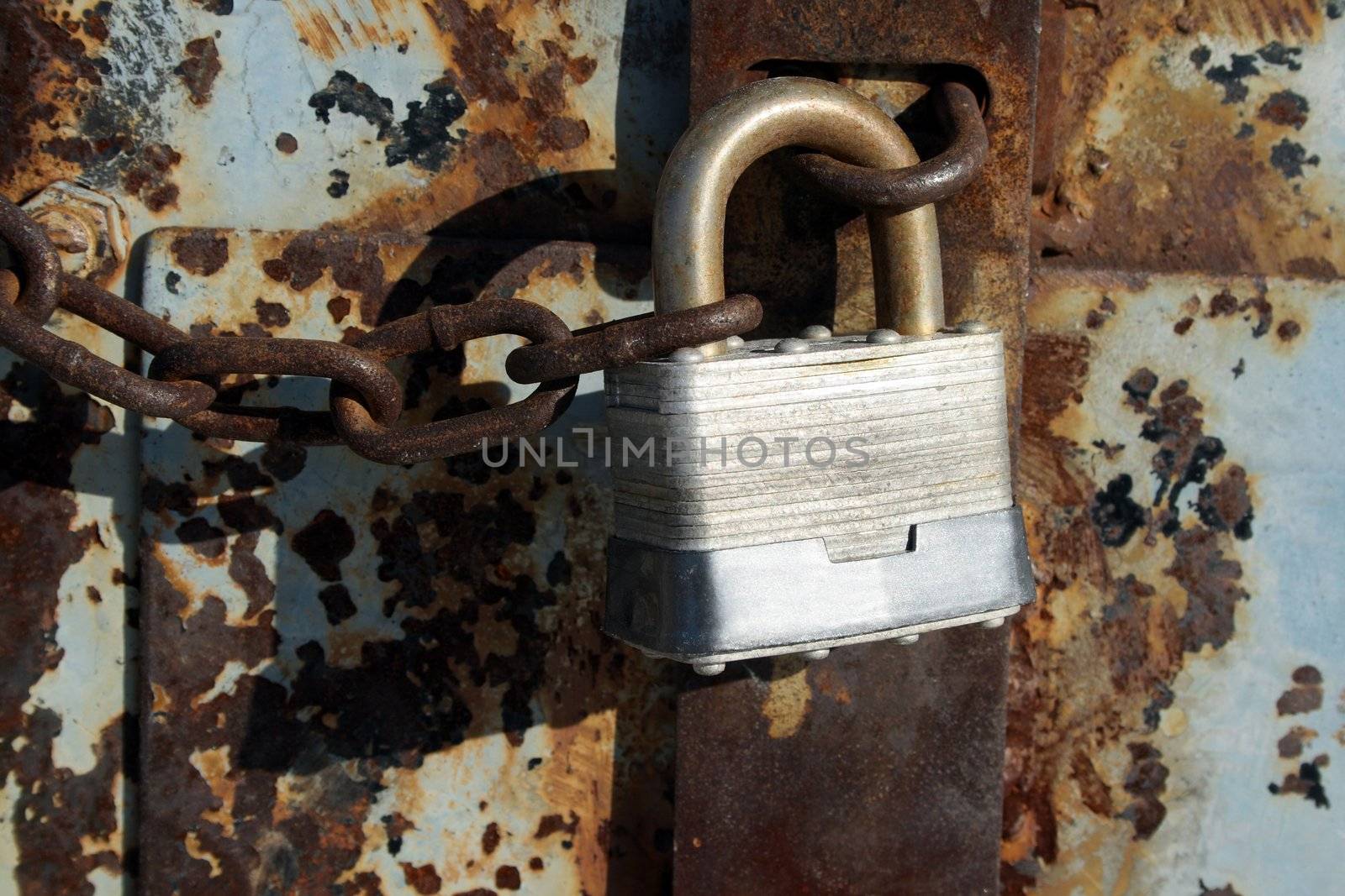 Iron lock and chain on an old rusty door.