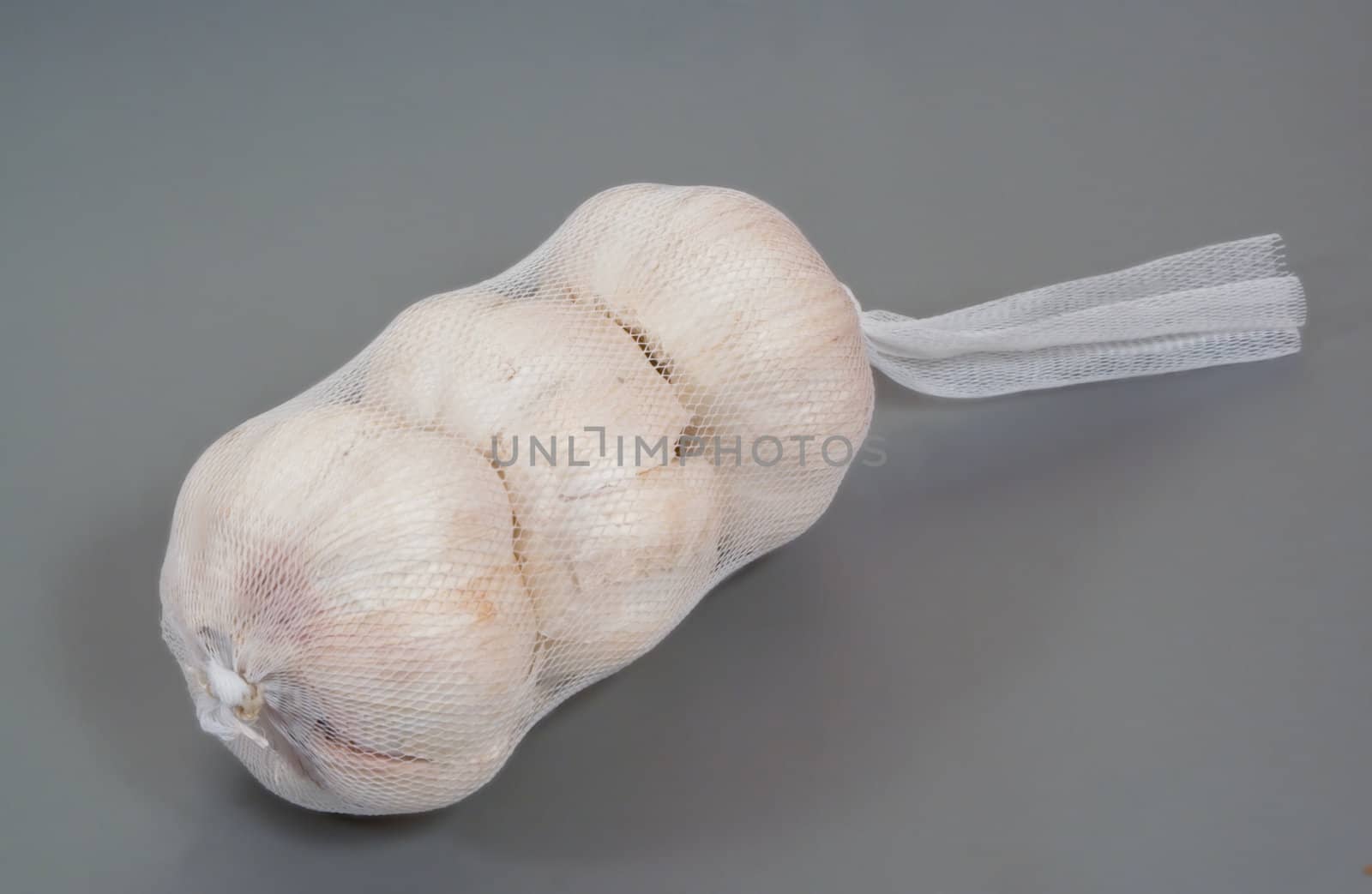 Three garlic bulbs in a net by tsvgloom