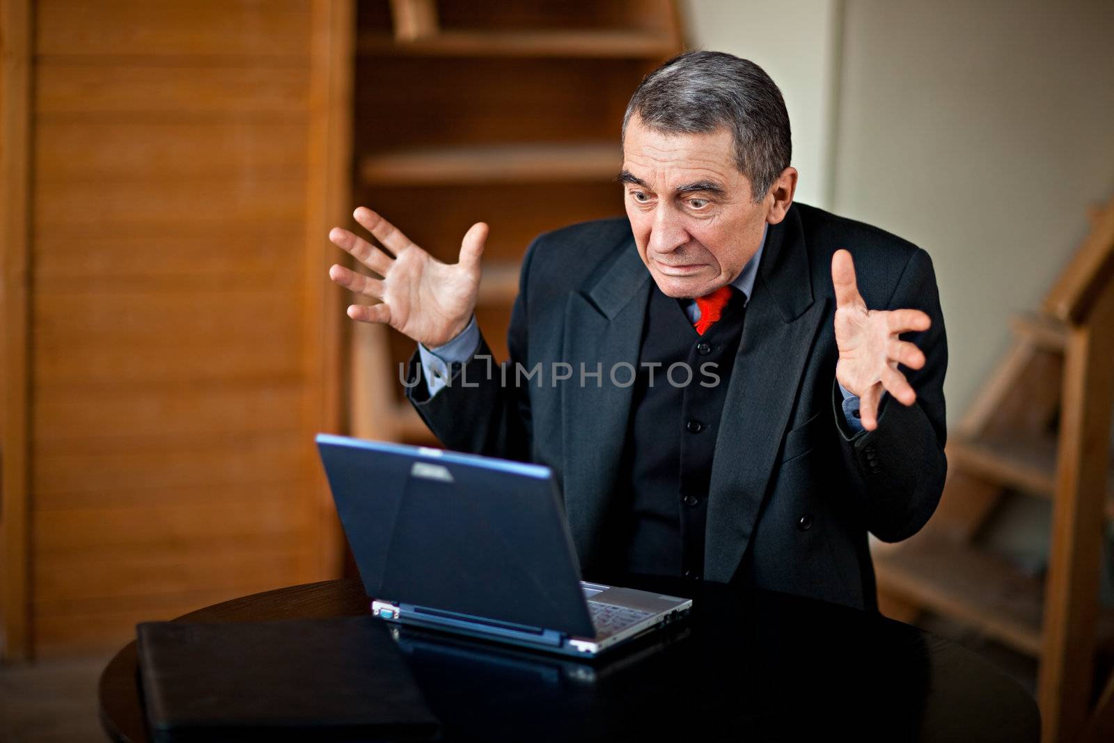 Shocked businessman working on a laptop