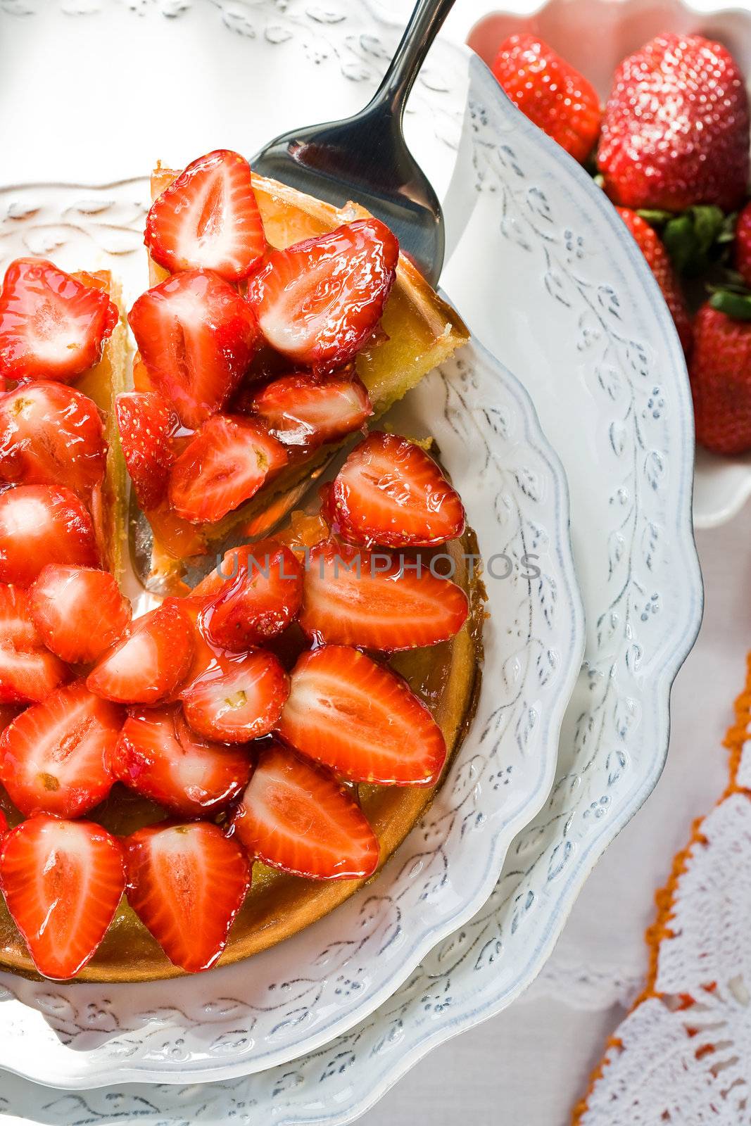Cheesecake with sliced fresh strawberries on plate
