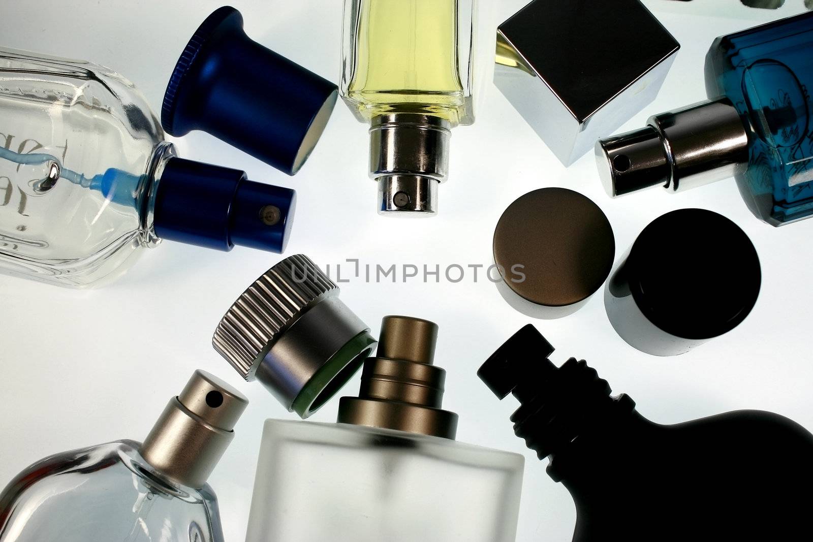 different shapes of perfume bottles and caps in white background