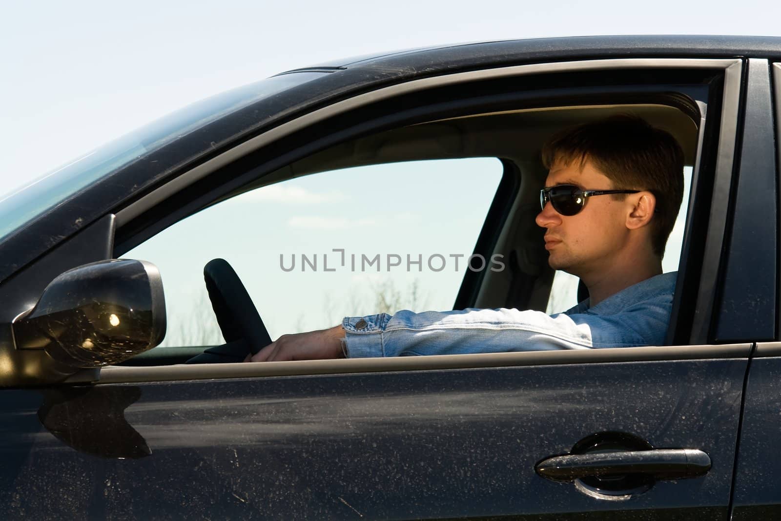 young man in the car at the wheel