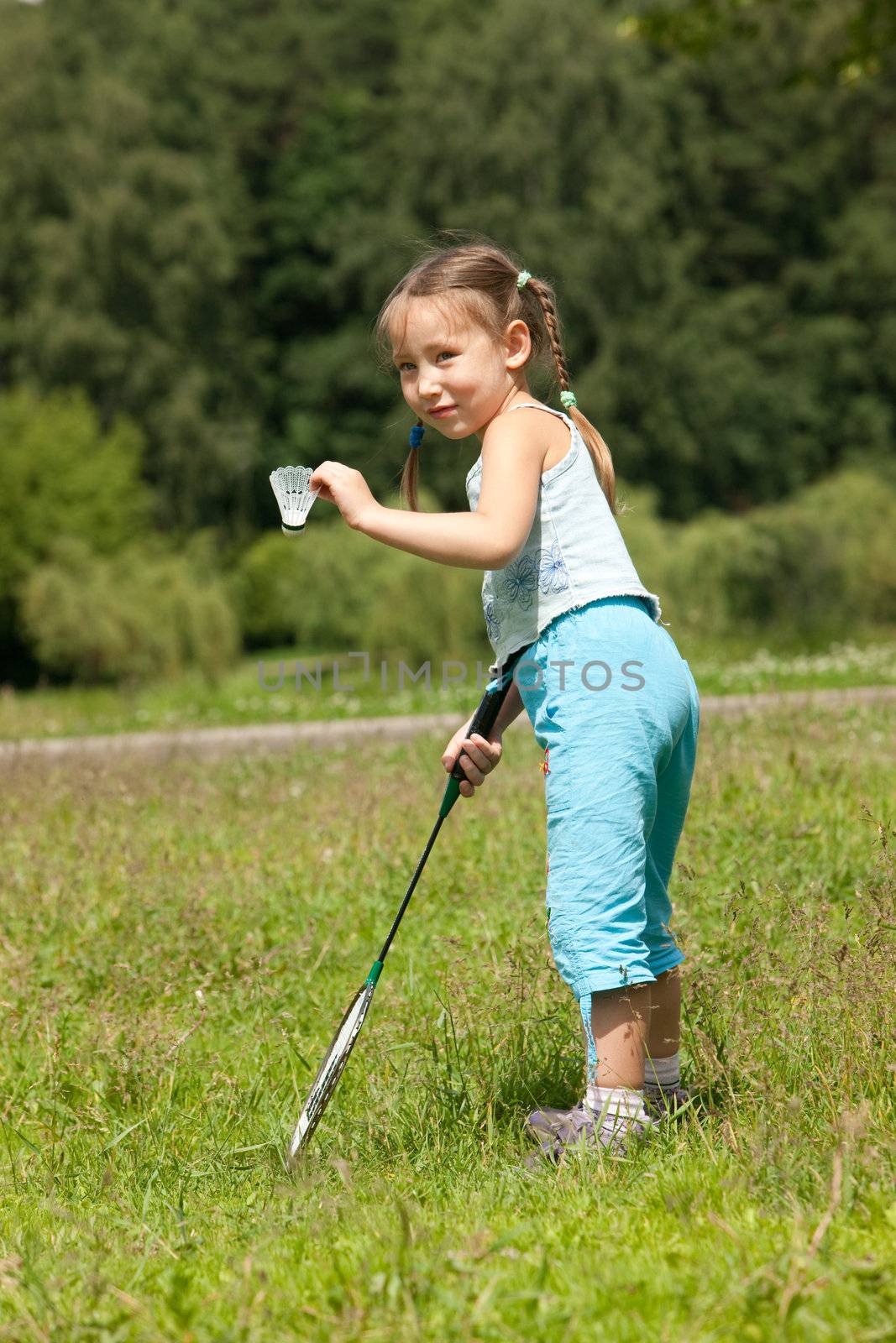Little girl holding a badminton racket and shuttlecock