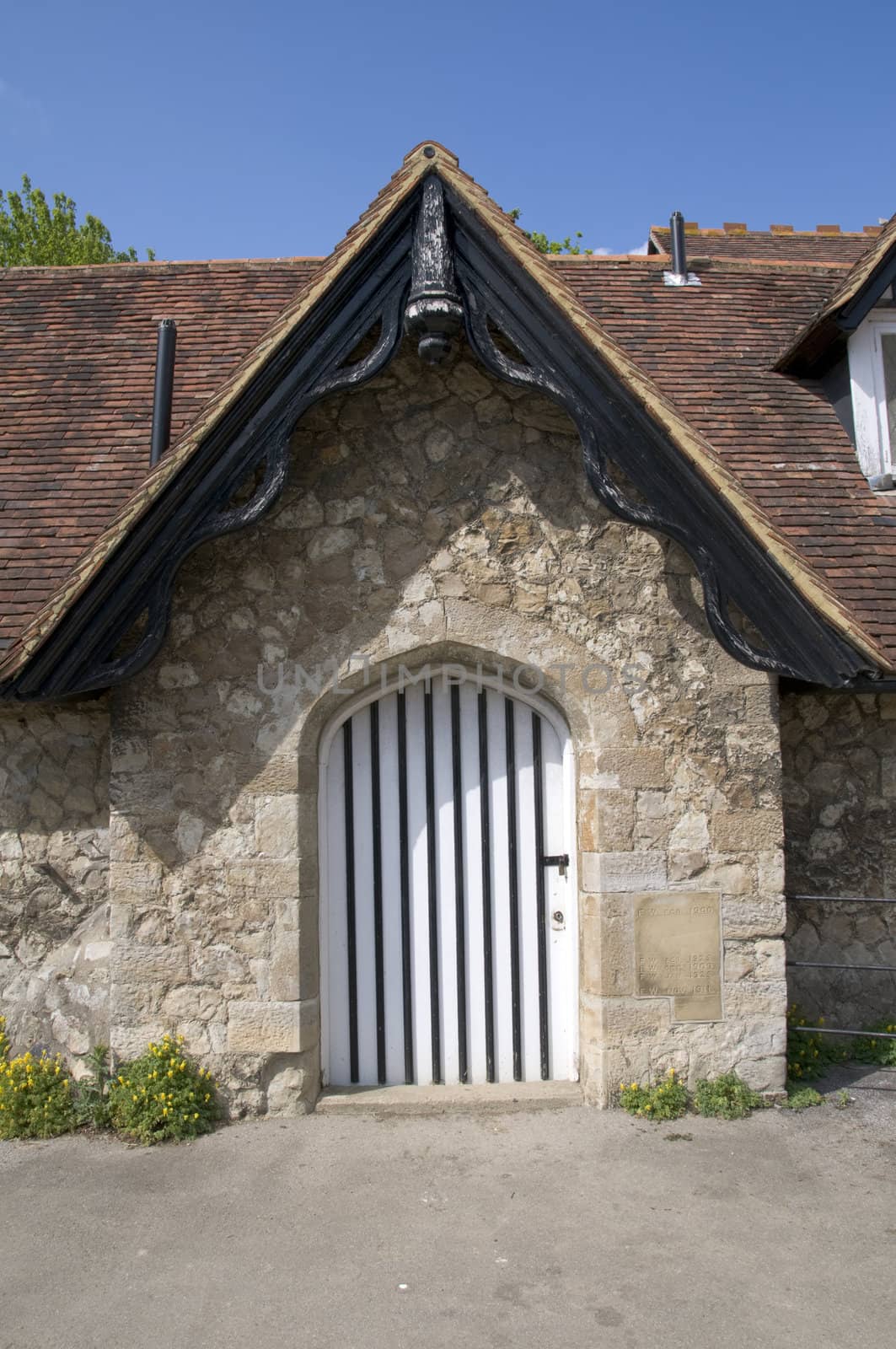 An old black and white door on a stone building