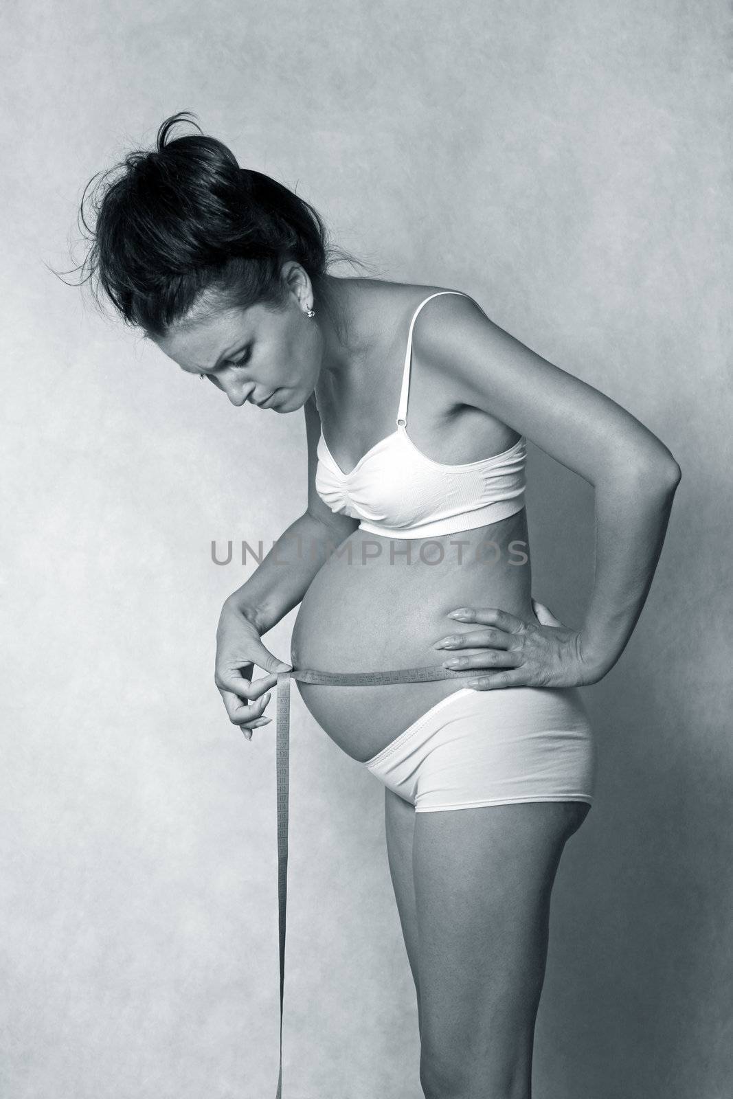 Pregnant woman measuring her a stomach
