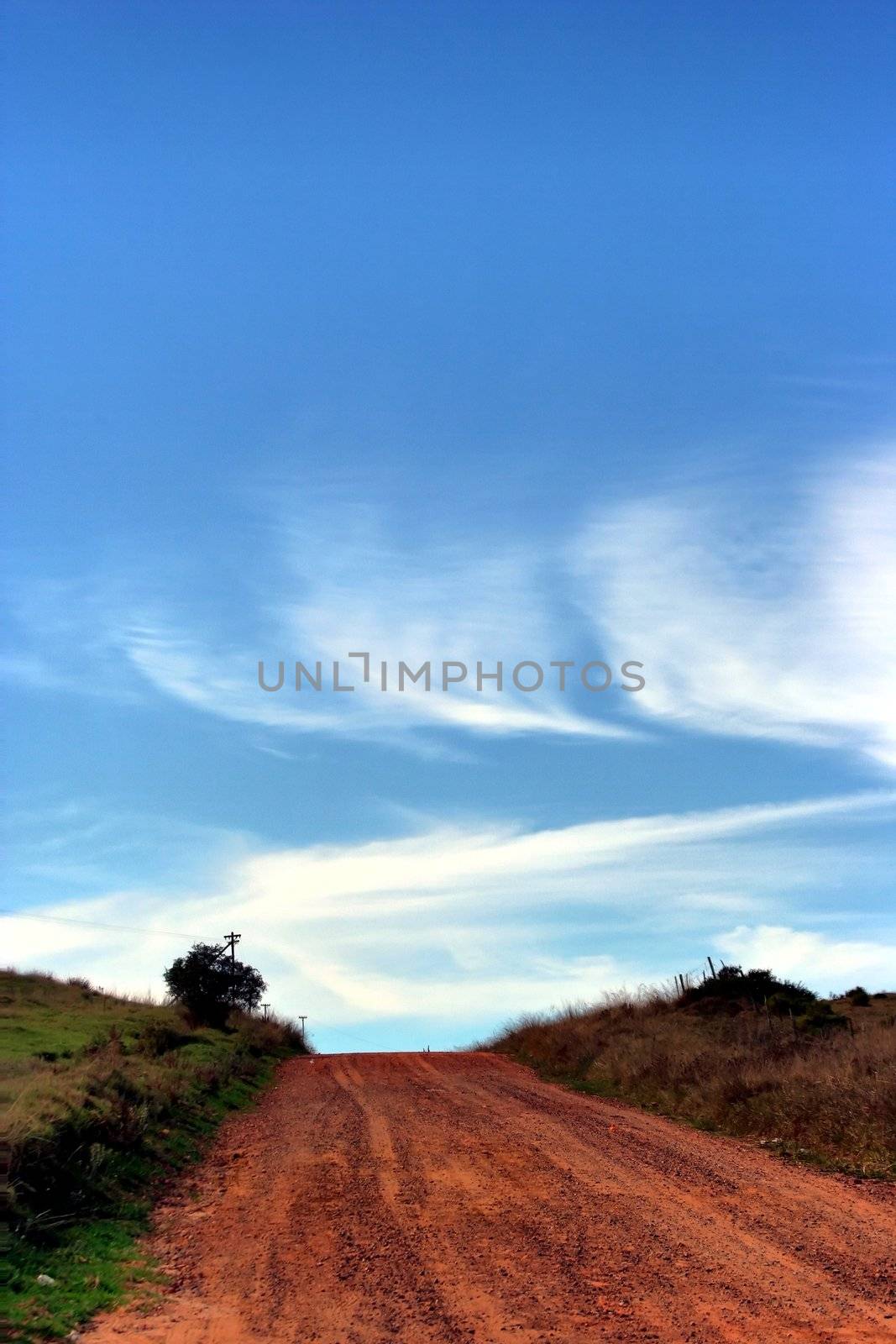 Dirt road in the country side and a blue sky