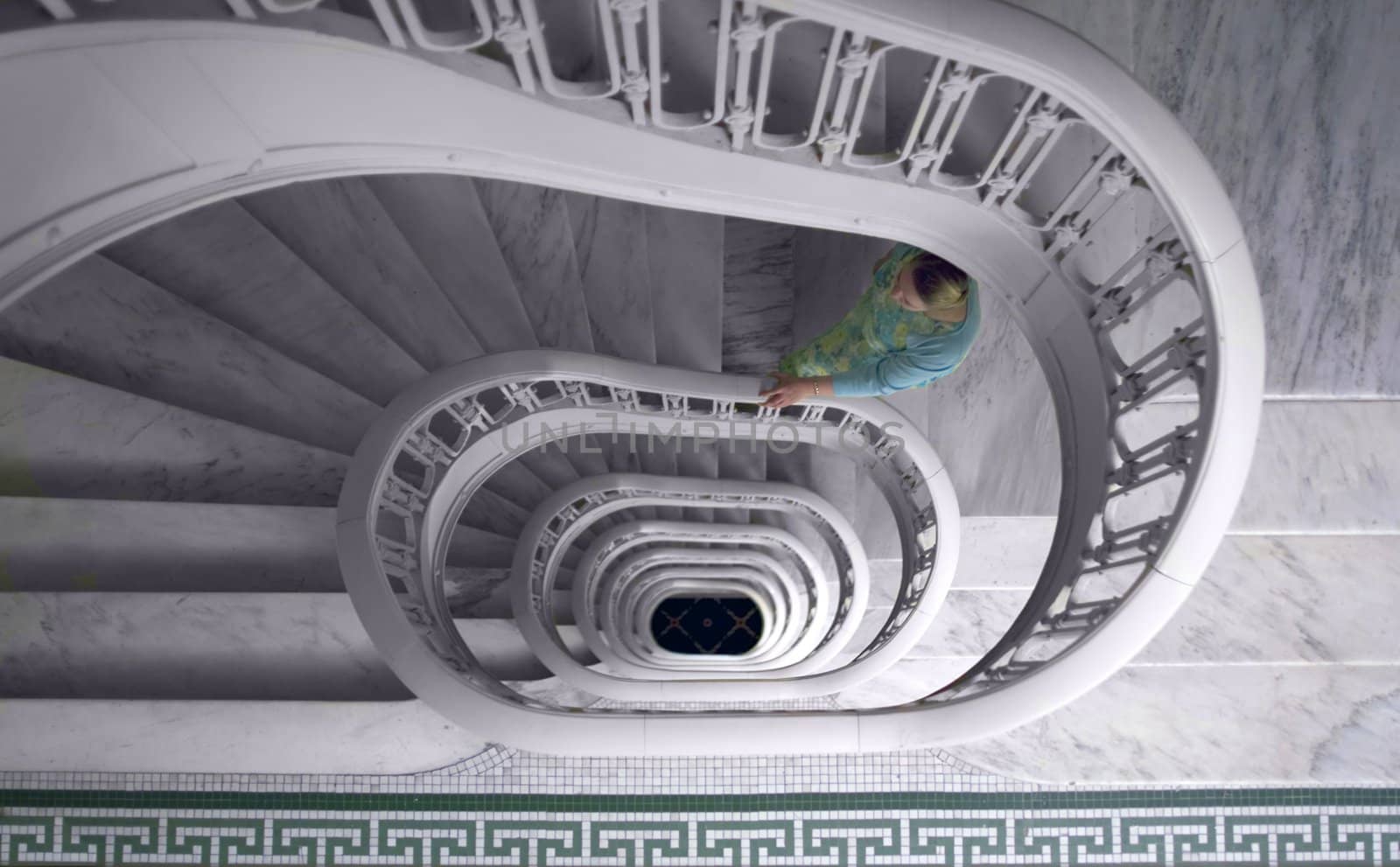 a woman climbing up a marble spiral staircase