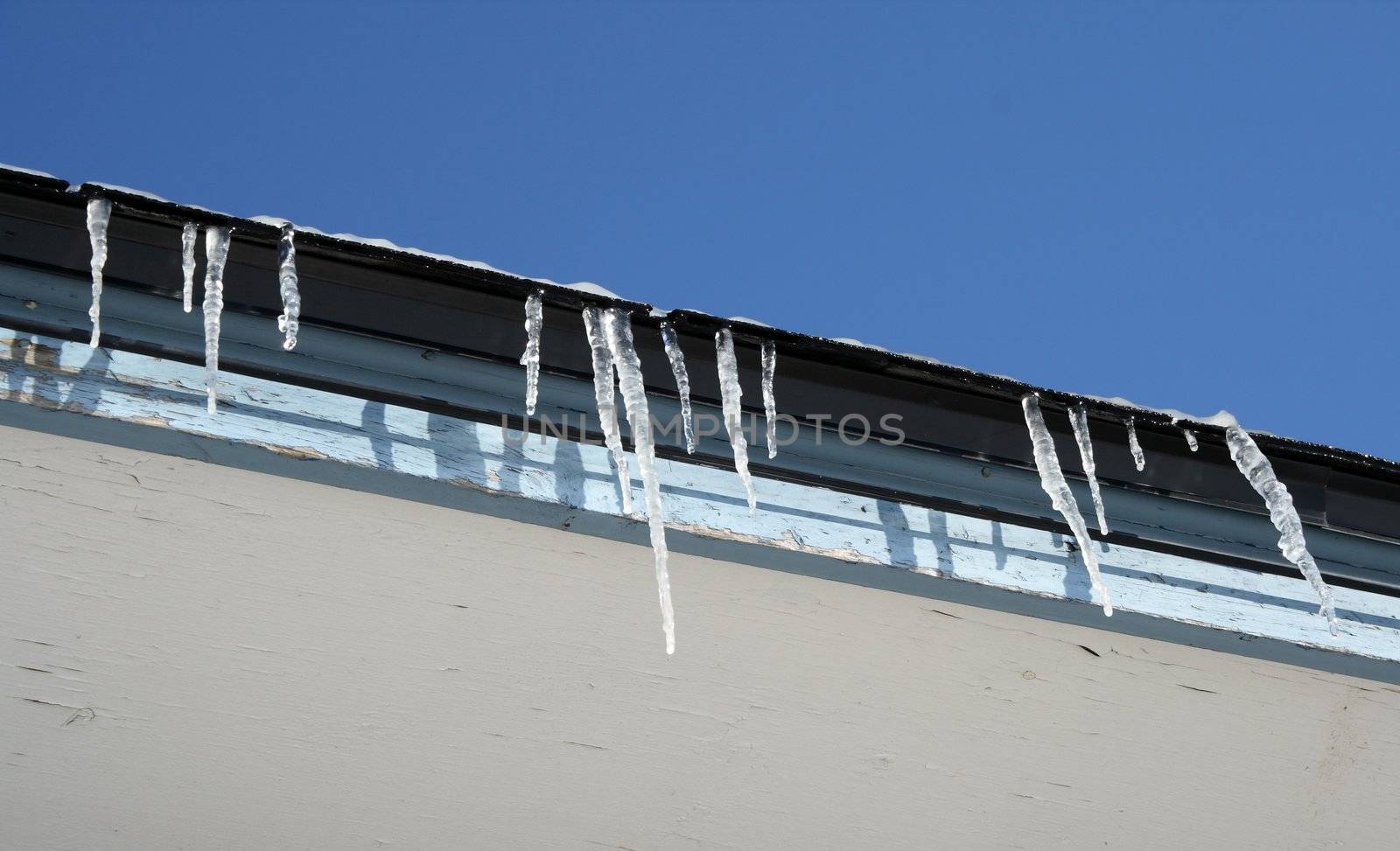 Bright winter day, icicles on the roof by anikasalsera