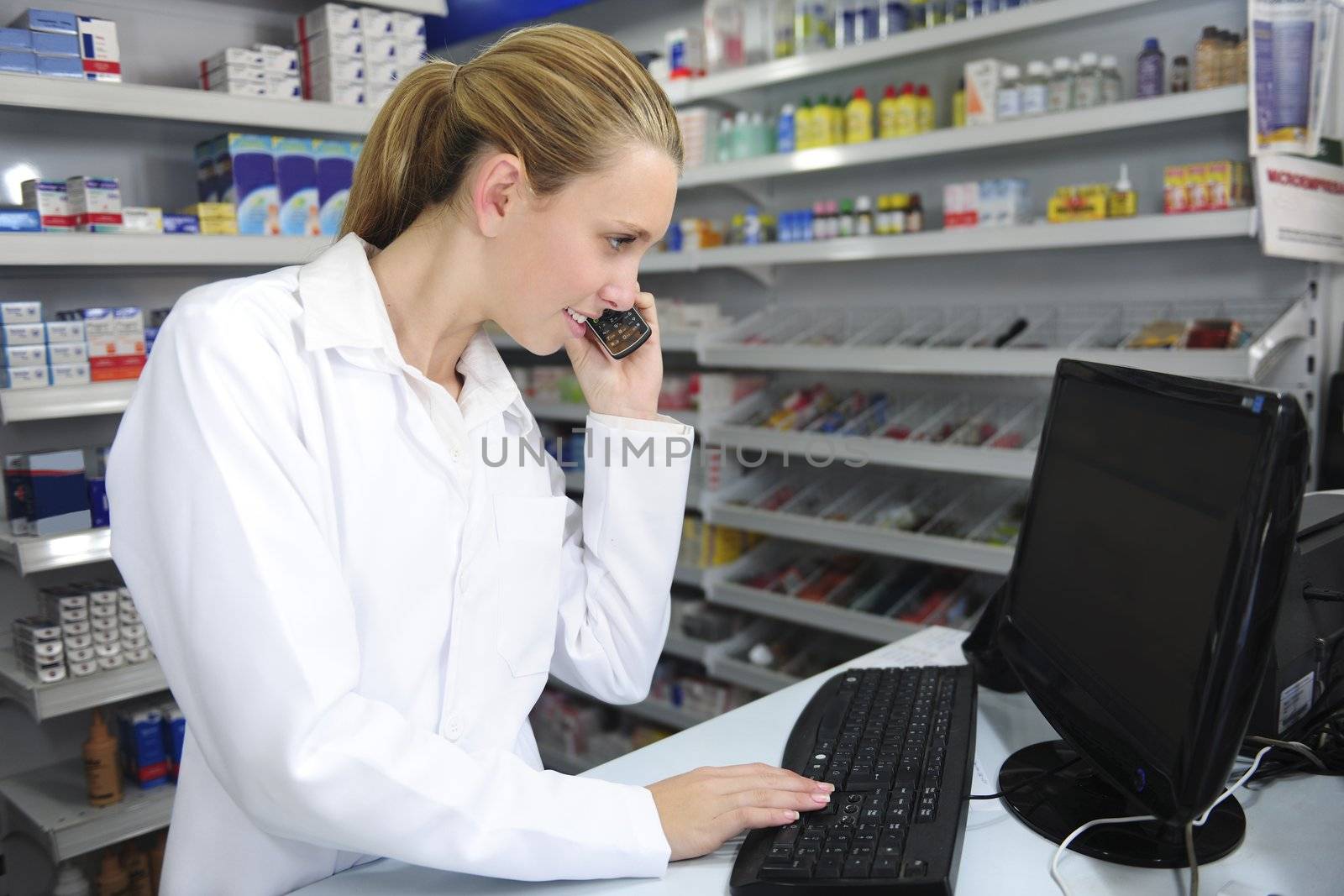 pharmacist using computer and telephone