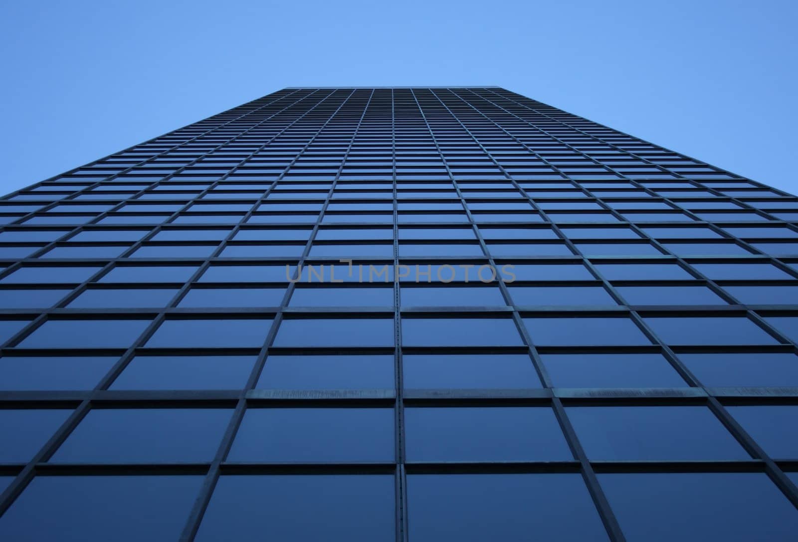Perspective view of a blue-windowed skyscraper, directly from below.