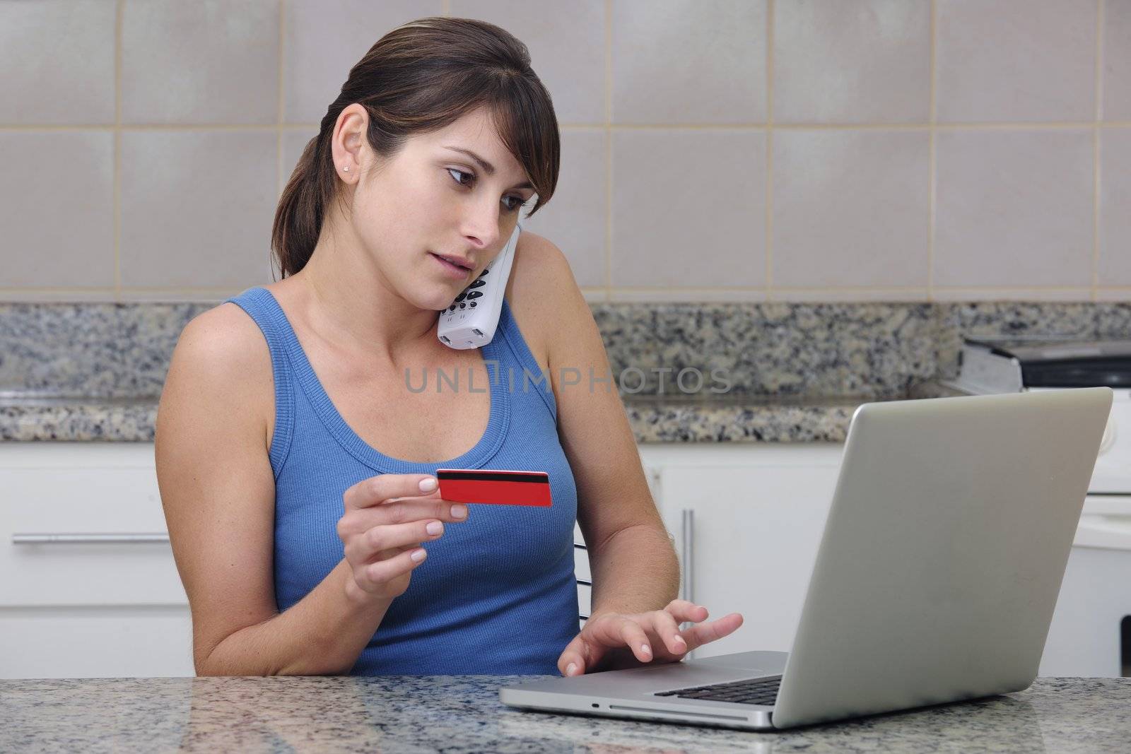 woman with creditcard calling on phone and using the internet