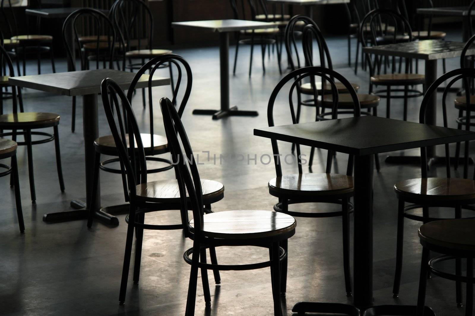 Tables and chairs in a cafeteria by anikasalsera