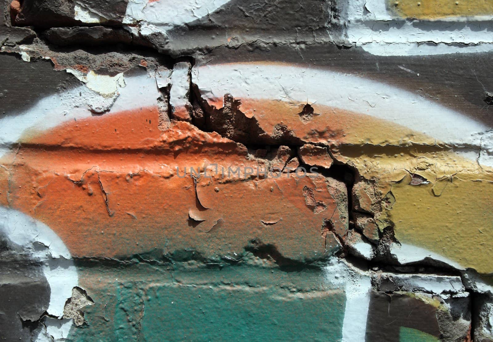 Urban decay. Colorful graffiti on a cracked brick wall.