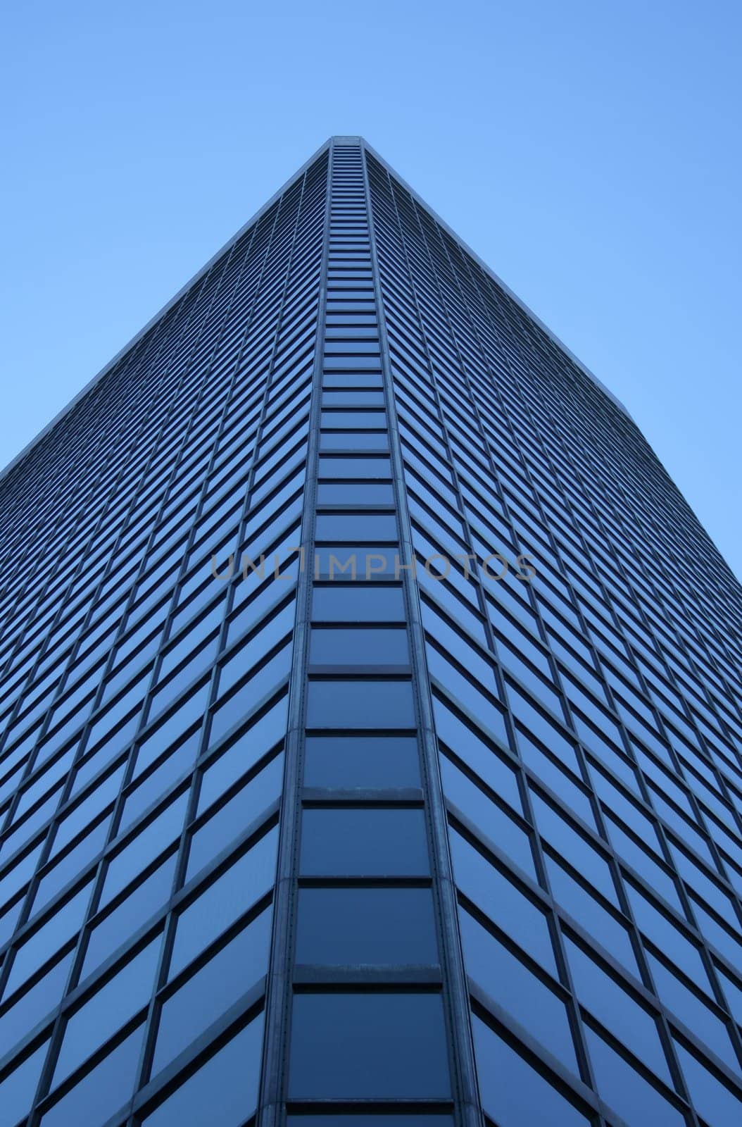 Angle view of a glass-windowed skyscraper by anikasalsera