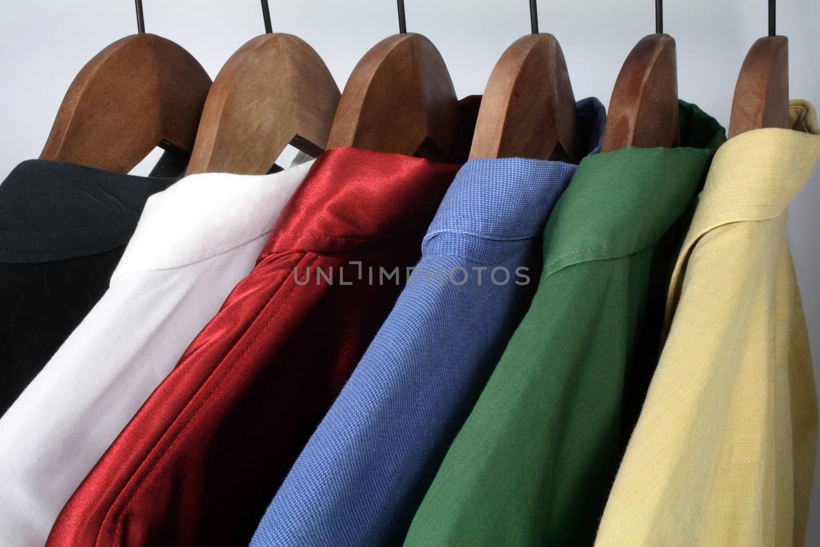 Man's clothing: choice of stylish colorful shirts on wooden hangers.