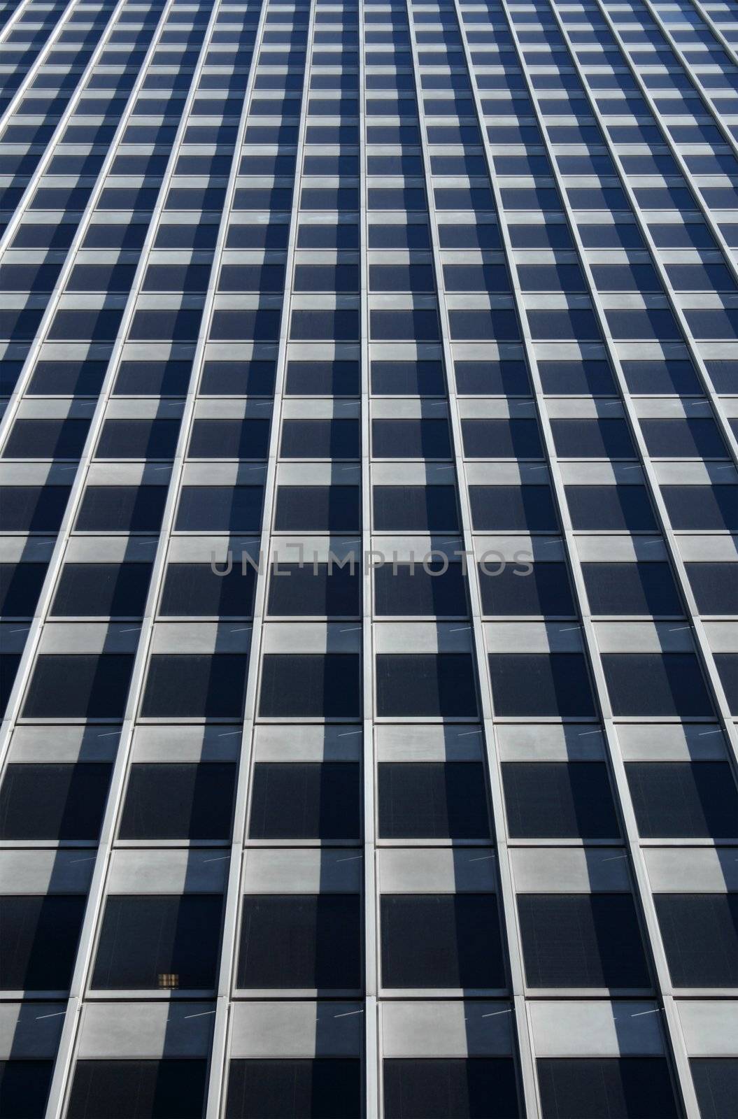 Concrete glass-windowed wall of a gray corporate building.