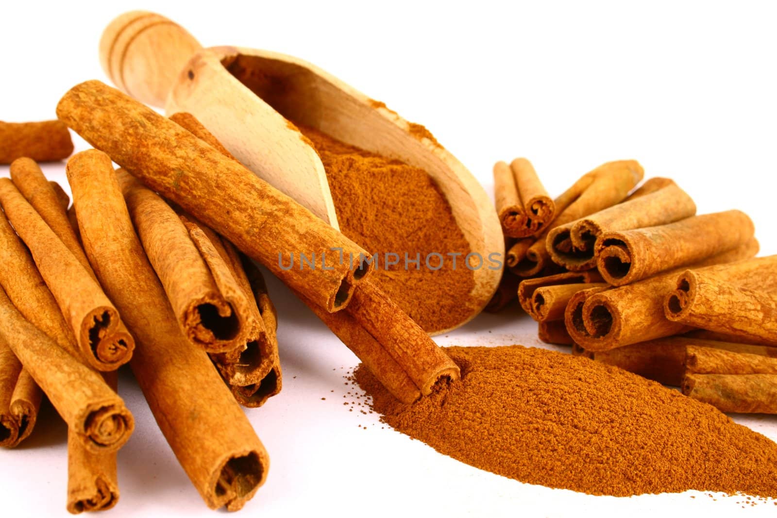 Sticks and powder of cinnamon reflected on the white background