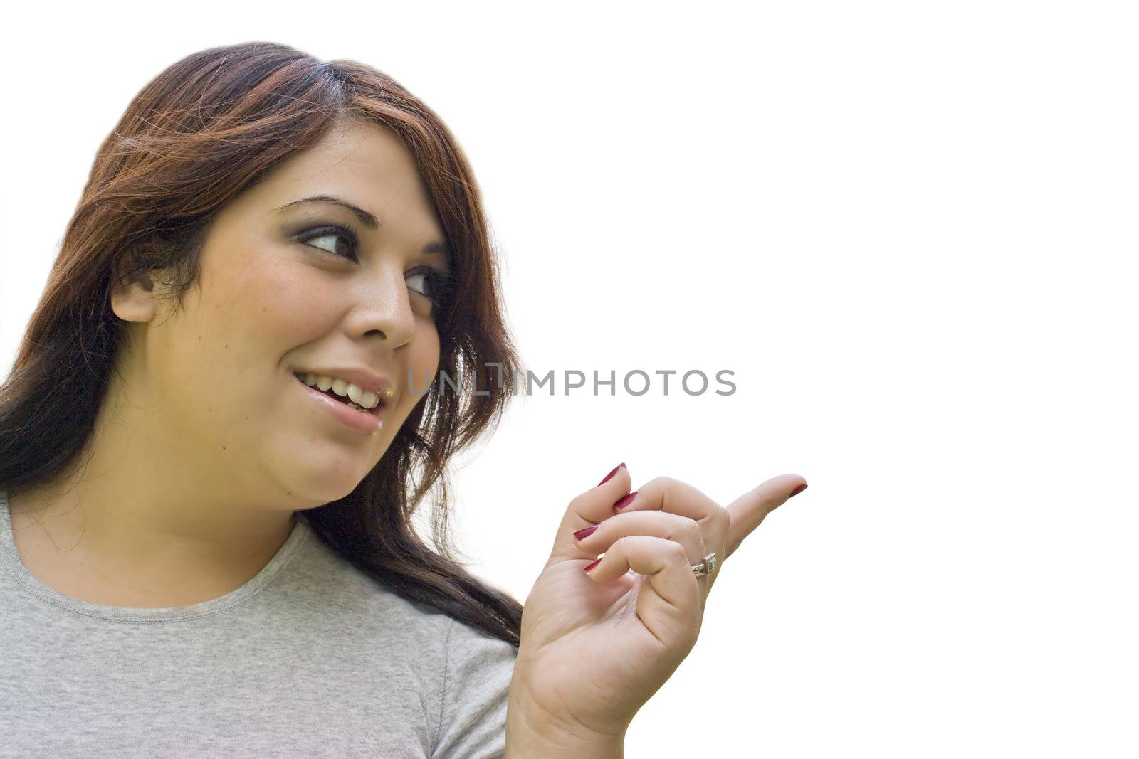 A young hispanic woman pointing to the right.  Plenty of copy space.