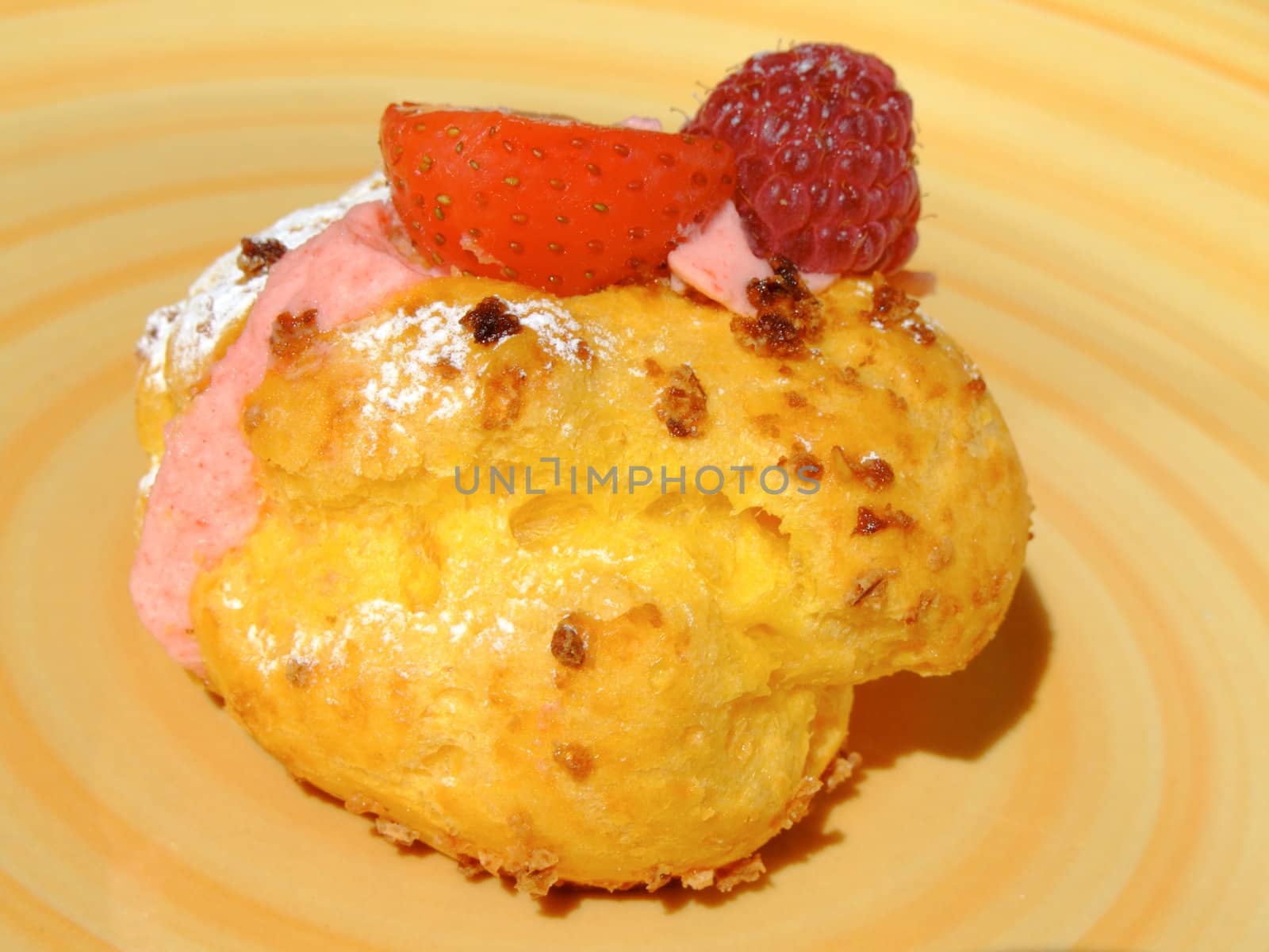 Puff dough filled with berries cream , decorated with strawberry, raspberry and icing sugar