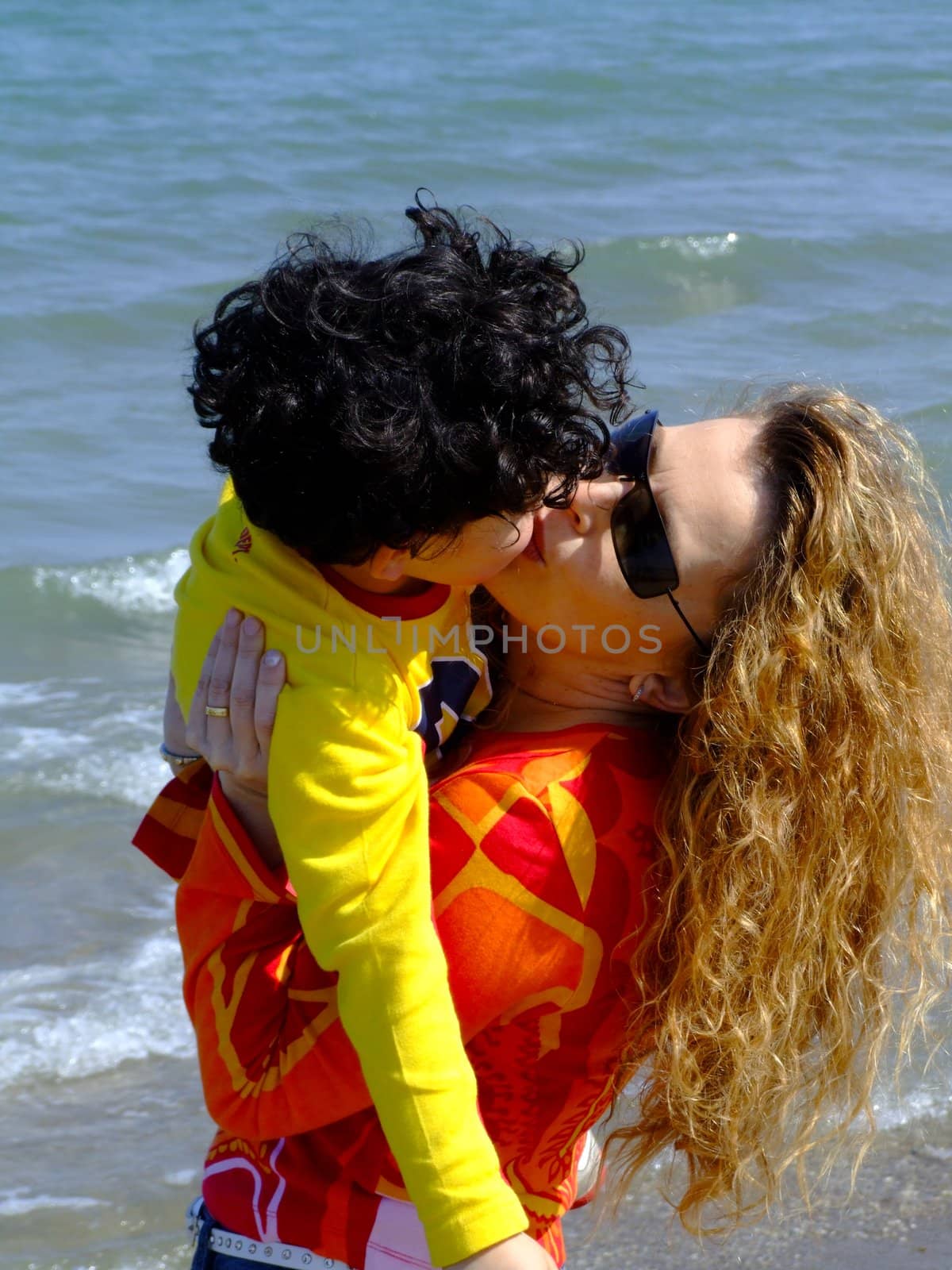 mother and child kissing on the beach