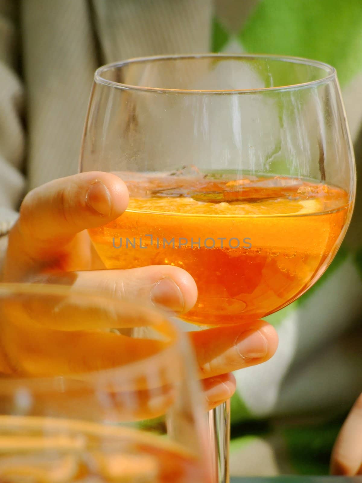 Hand holding a long drink glass during happy hour