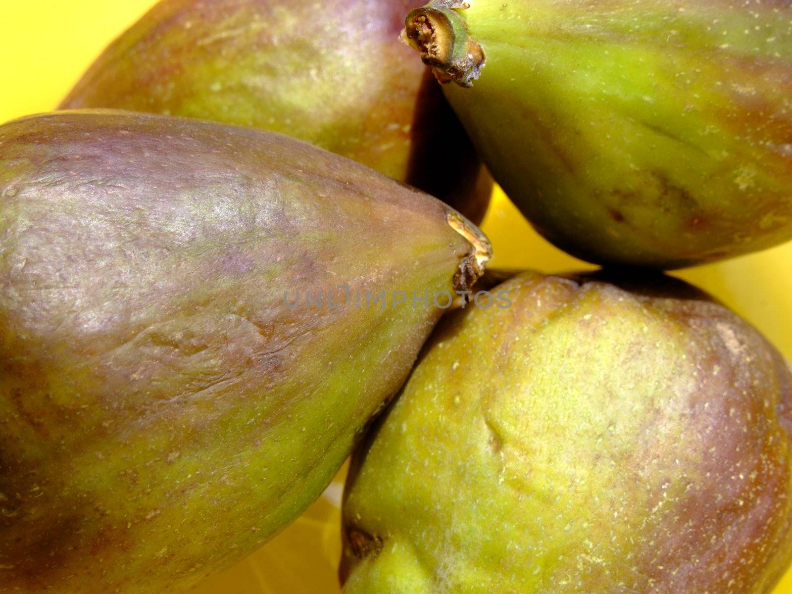 Four ripe figs in a yellow bowl
