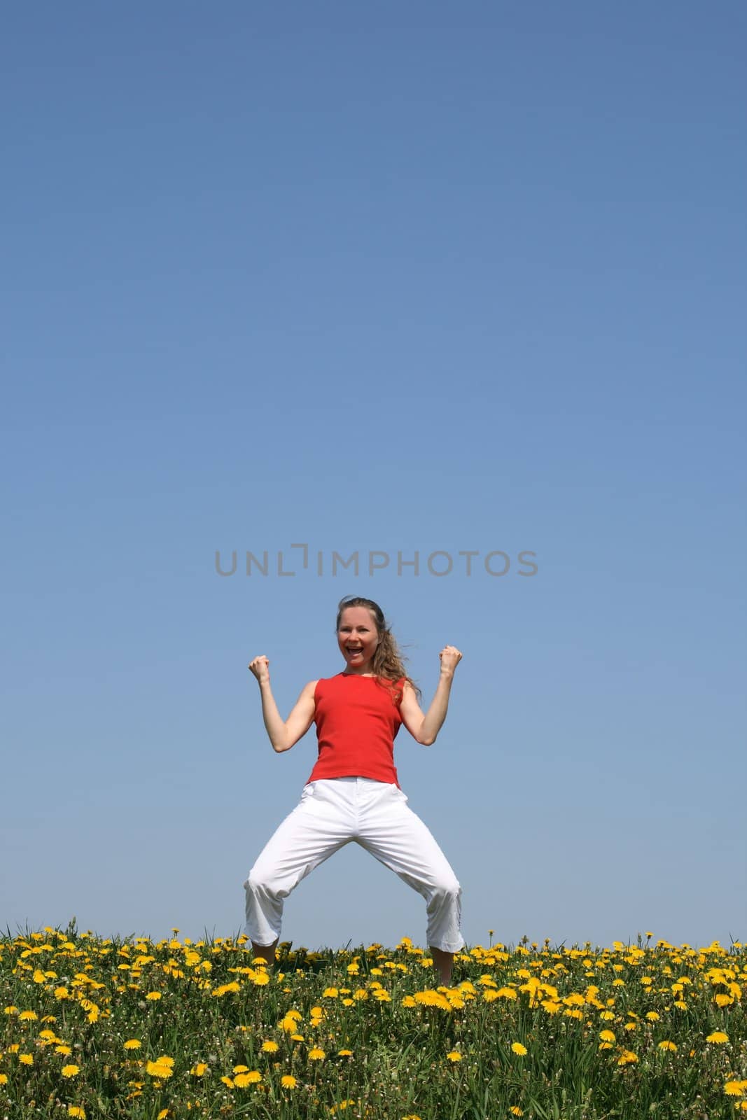Sporty girl in a flowering field, yelling "yeah!"