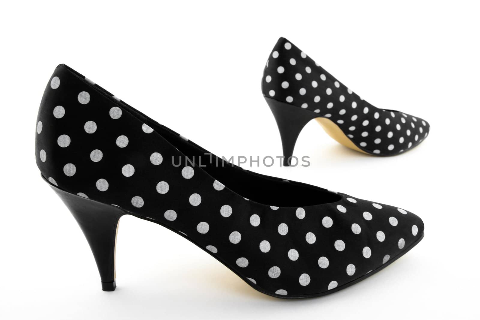 Black classic high heel polka shoes. Focus on the closest shoe.